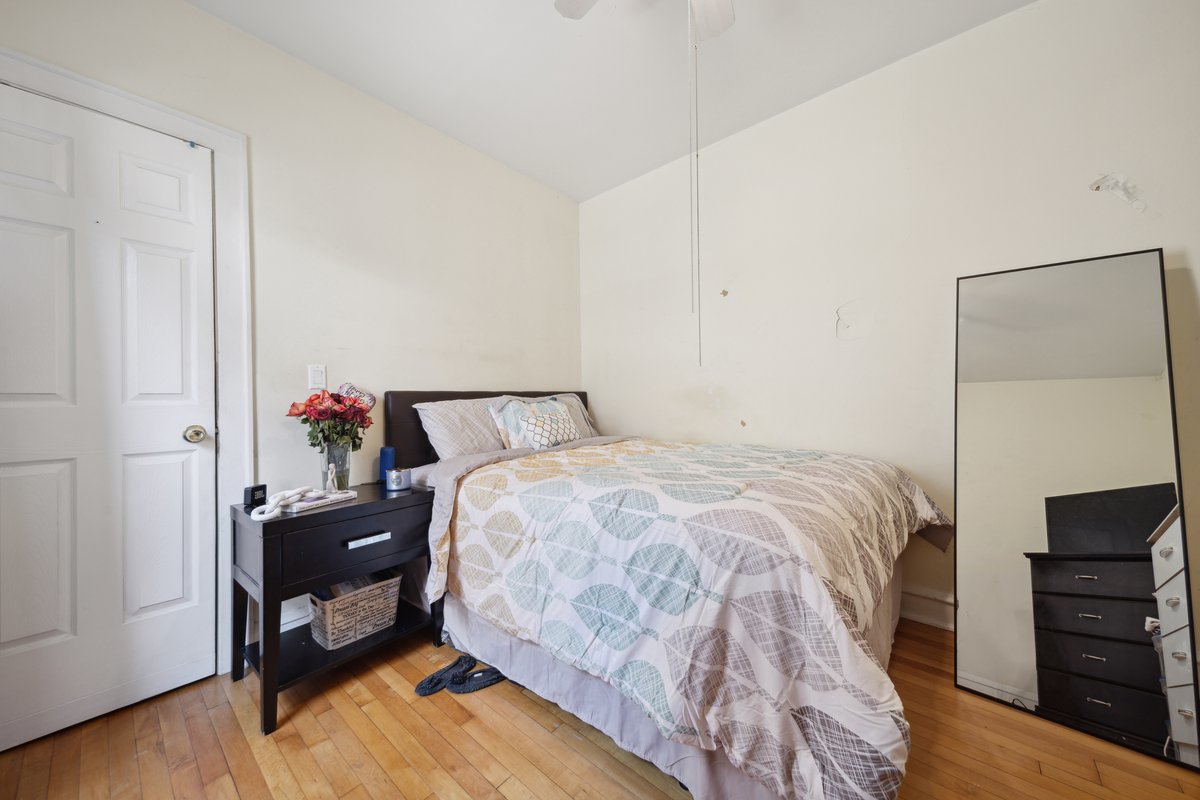4703 West Parker Avenue Chicago, IL 60639 - Photo 5 of 27 a bed sitting in a bedroom next to a cabinet