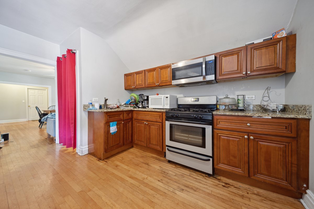 4703 West Parker Avenue Chicago, IL 60639 - Photo 10 of 27 a kitchen with stainless steel appliances granite countertop a stove a sink dishwasher and cabinets with wooden floor