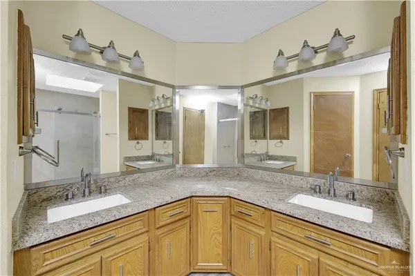 a bathroom with a granite countertop sink double vanity and mirror