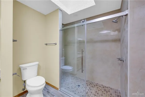 a bathroom with a granite countertop toilet and a shower