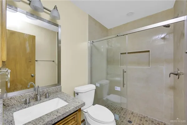 a bathroom with a granite countertop sink toilet and shower
