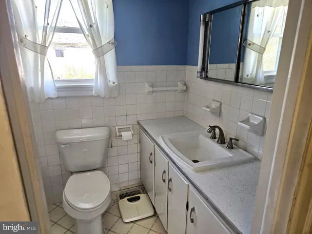 a bathroom with a sink a toilet and a window