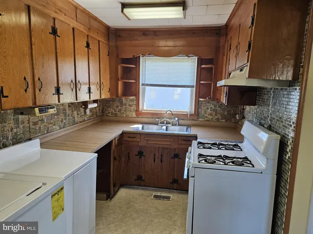 a kitchen with stainless steel appliances a sink stove and cabinets