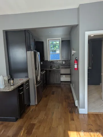 a kitchen with stainless steel appliances granite countertop a refrigerator and a sink