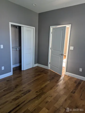 a view of empty room with wooden floor and window