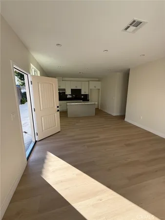 a view of a kitchen with wooden floor and electronic appliances