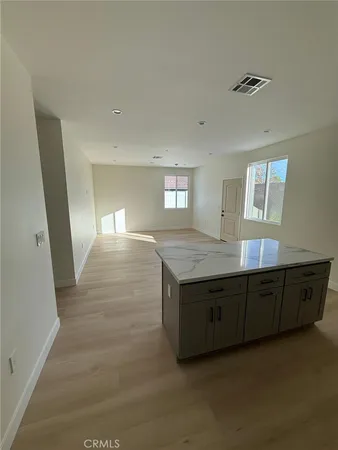 a kitchen with stainless steel appliances a sink a microwave a refrigerator and cabinets