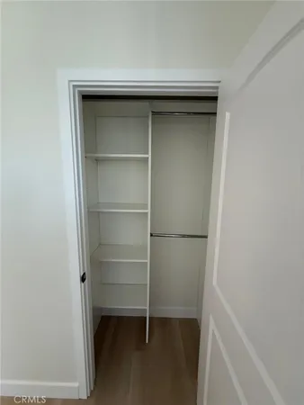 an empty room with wooden floor and entrance