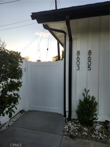 a view of a door and car parked in the road