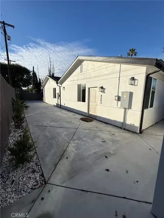 a view of a refrigerator in kitchen and an empty room