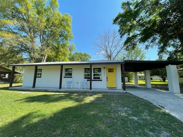 a view of a house with a yard and a tree