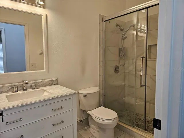 a bathroom with a granite countertop sink toilet and shower
