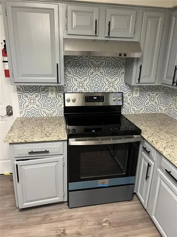 a stove top oven sitting inside of a kitchen