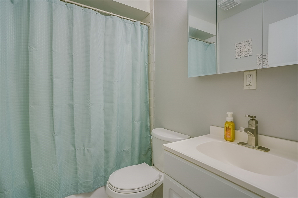 11 Cross Street, Unit 3 Chelmsford, MA 01863 - Photo 10 of 13 a bathroom with a sink a toilet and shower curtain