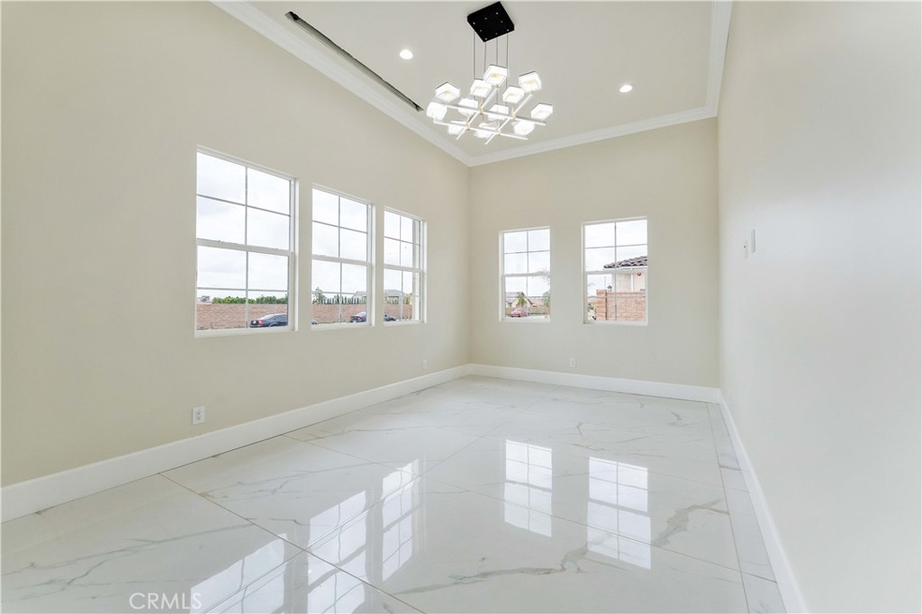 6338 Echo Mountain Rancho Cucamonga, CA 91739 - Photo 18 of 23 en empty room with windows and chandelier