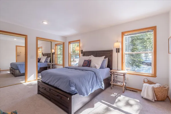 a living room with a bed couch and two large window