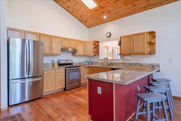 a kitchen with granite countertop a sink stove and refrigerator