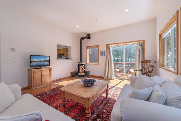 a living room with furniture a flat screen tv and a large window