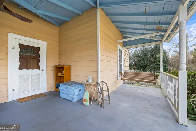 a view of a porch with a floor to ceiling window with wooden floor