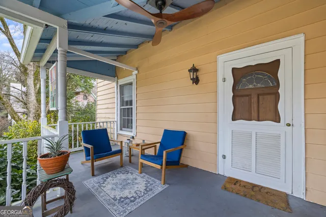 a view of hallway with wooden floor and fan