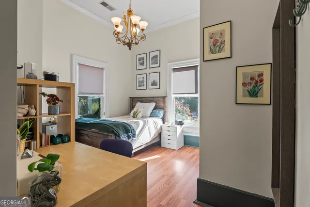 a bedroom with a bed table chair and a window