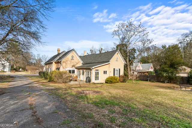 a view of a house with backyard and a tree