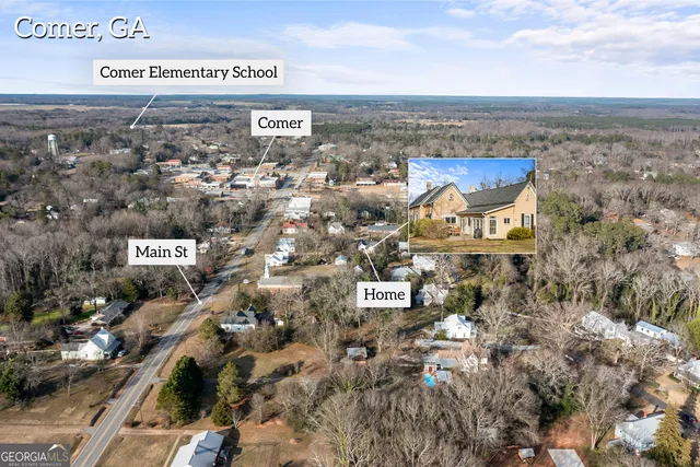 an aerial view of a house with a yard and large tree