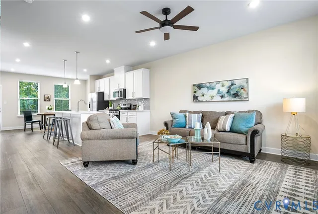 a living room with furniture and a view of kitchen