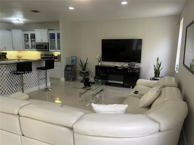 a kitchen with stainless steel appliances granite countertop a stove top oven a sink a counter space and cabinets