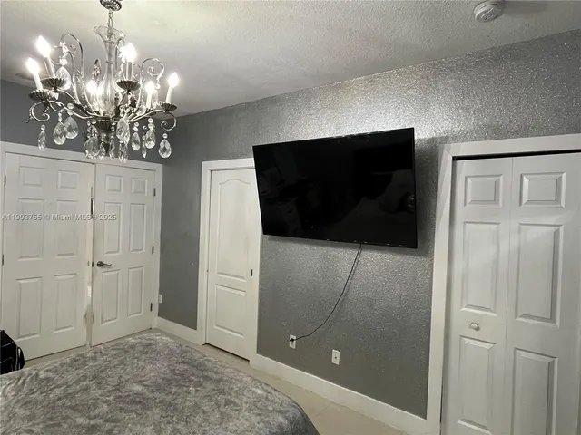 a large bed sitting in a bedroom next to a chandelier
