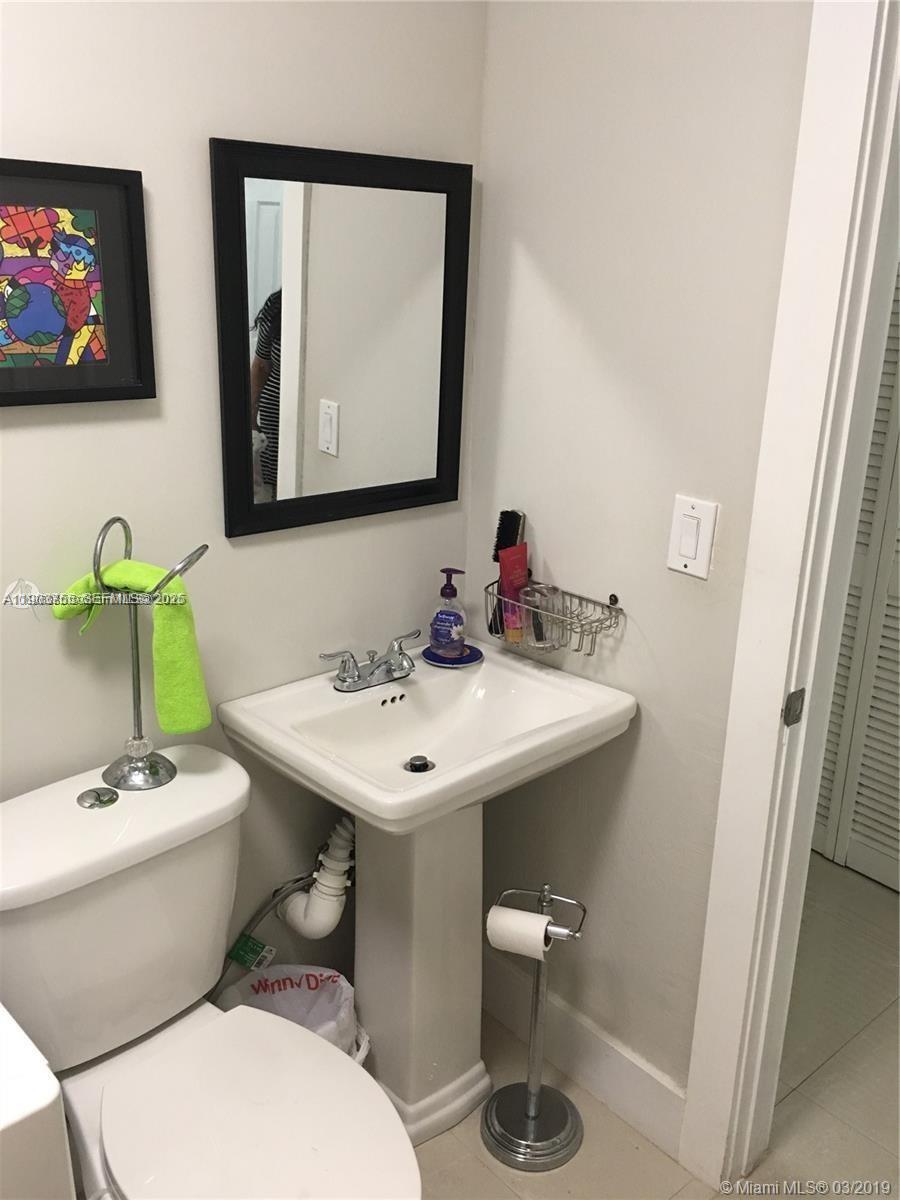 16801 Southwest 38th Street Miramar, FL 33027 - Photo 28 of 63 a bathroom with a toilet a sink and mirror