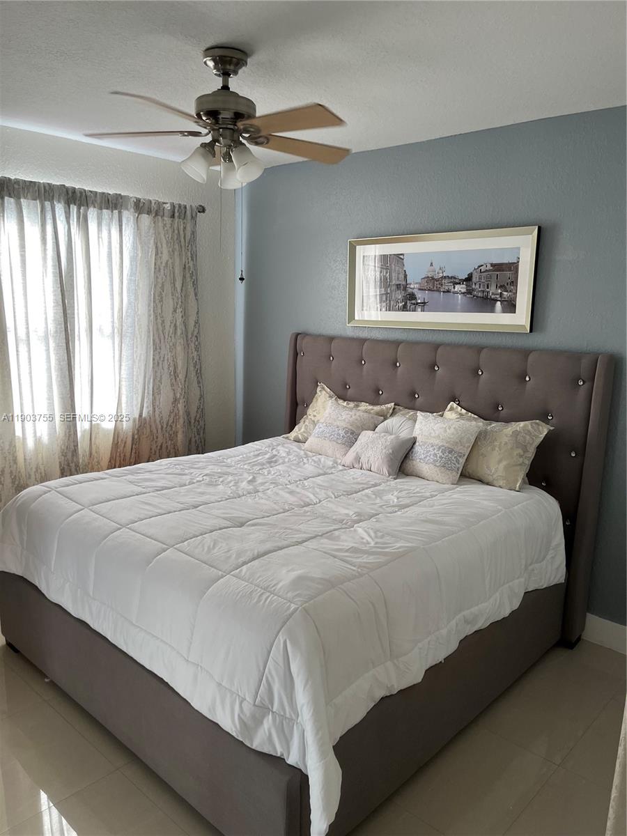 16801 Southwest 38th Street Miramar, FL 33027 - Photo 31 of 63 a large bed sitting in a bedroom next to a chandelier