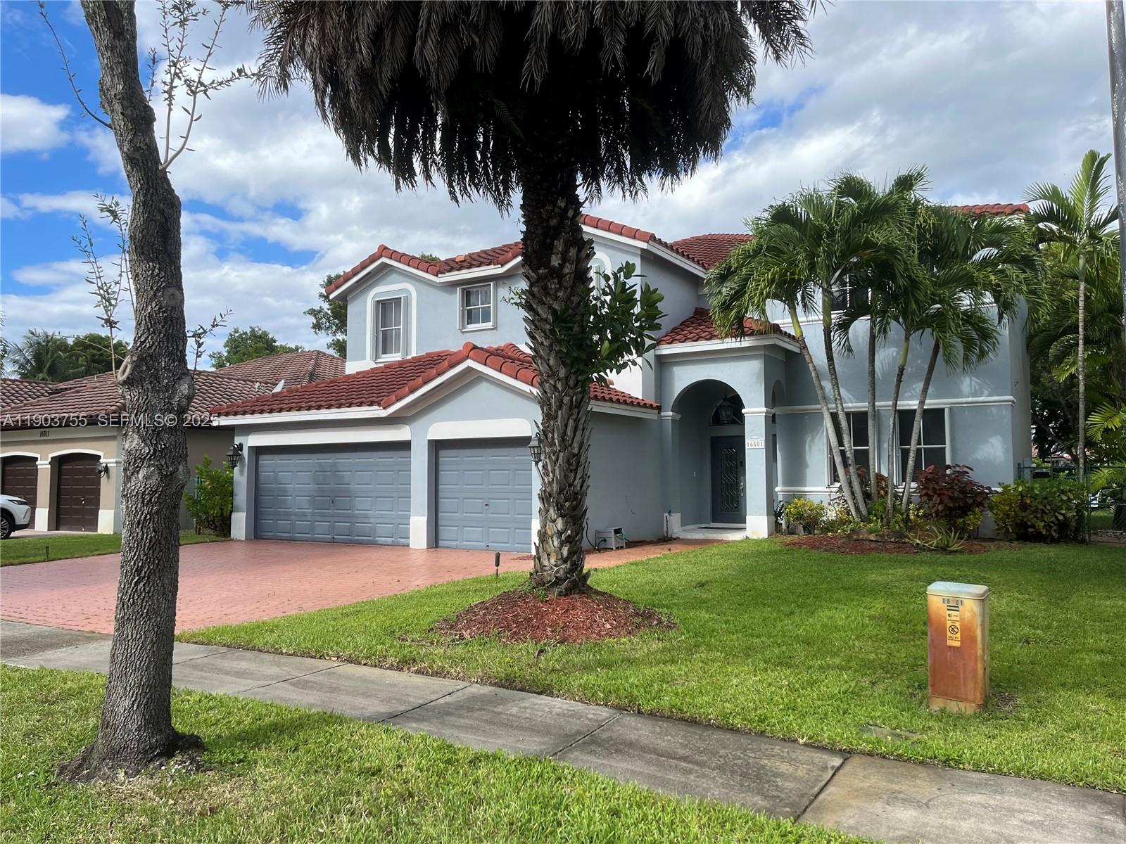 16801 Southwest 38th Street Miramar, FL 33027 - Photo 4 of 63 a front view of a house with a garden and trees