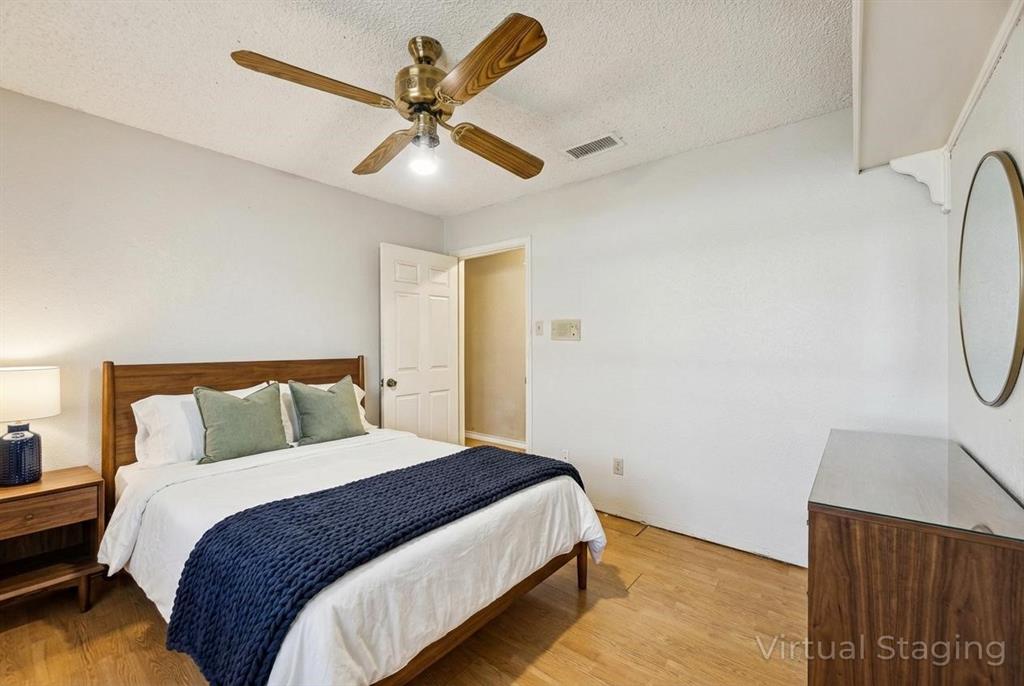 241 Simmons Road Double Oak, TX 75077 - Photo 18 of 40 Bedroom featuring light wood-style flooring, a ceiling fan, and a textured ceiling