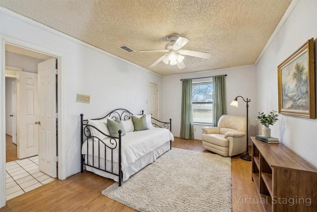 241 Simmons Road Double Oak, TX 75077 - Photo 19 of 40 Bedroom featuring light wood-style flooring, a textured ceiling, ceiling fan, and crown molding