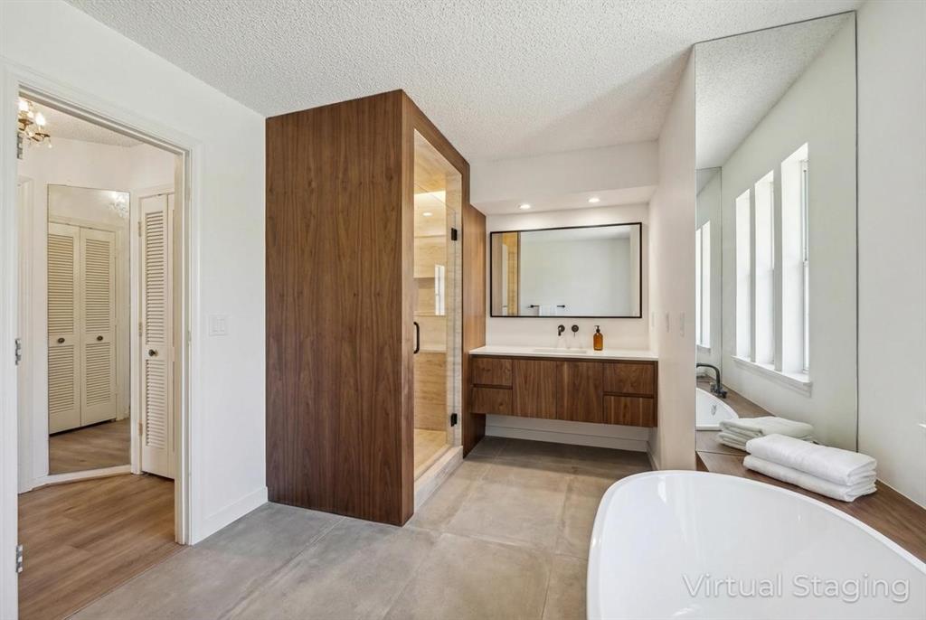 241 Simmons Road Double Oak, TX 75077 - Photo 28 of 40 Bathroom featuring a freestanding tub, vanity, a textured ceiling, a stall shower, and a closet