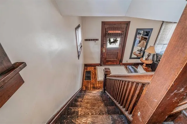 a view of a hallway with wooden floor and stairs