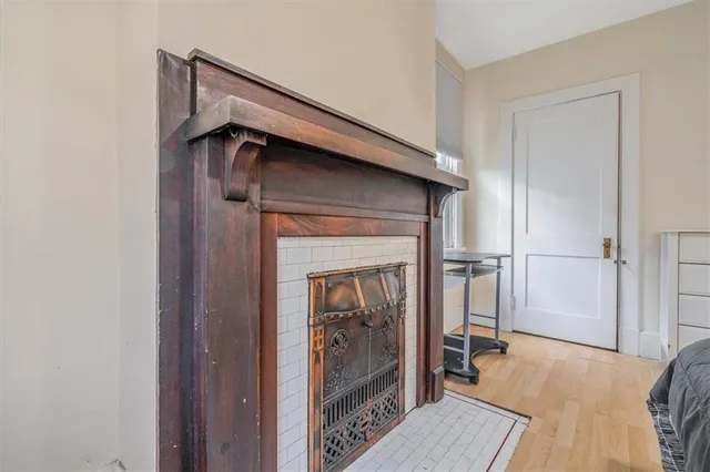 an empty room with windows and fireplace