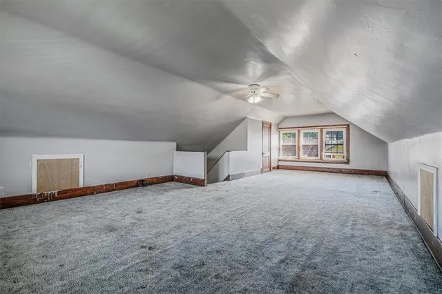 an empty room with windows and fireplace