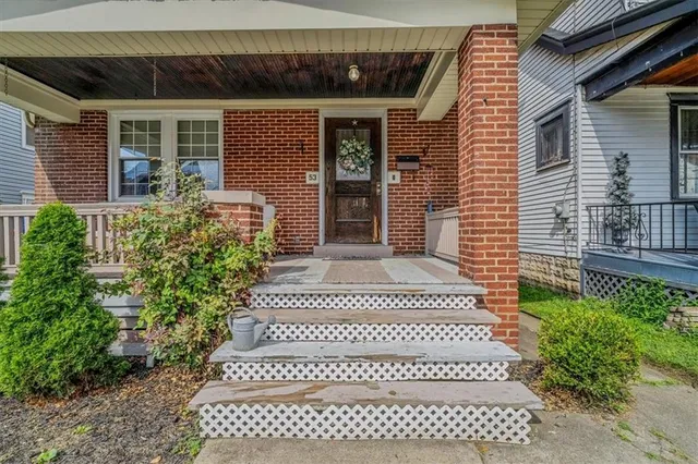a front view of a house with garden and porch