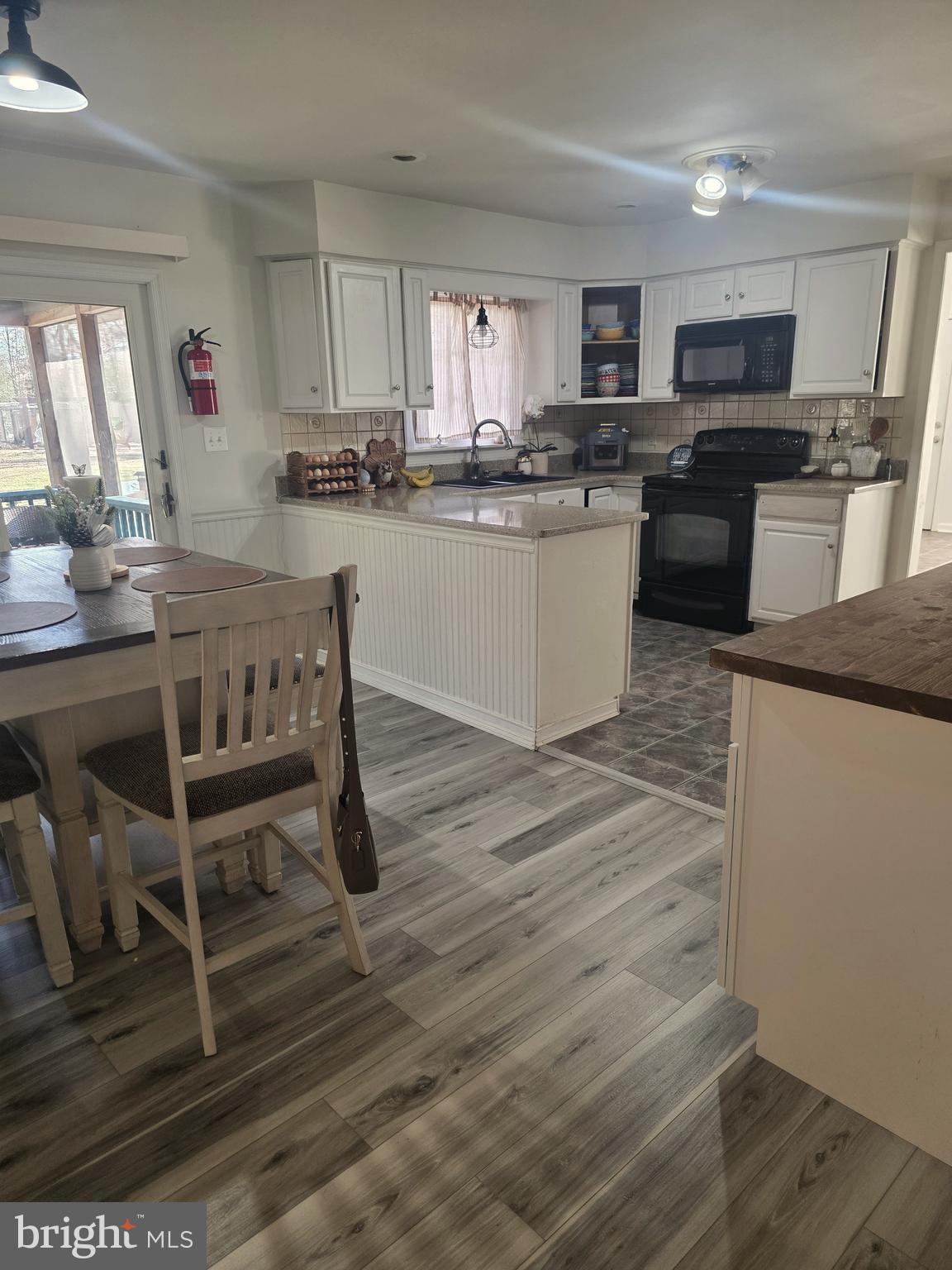 537 Centerton Road Pittsgrove, NJ 08318 - Photo 15 of 28 a kitchen with granite countertop a stove top oven a sink dishwasher a dining table and chairs with wooden floor