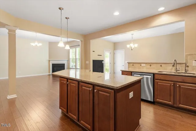 a kitchen with stainless steel appliances granite countertop a sink a stove and a refrigerator