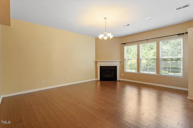 a view of a room with wooden floor and kitchen