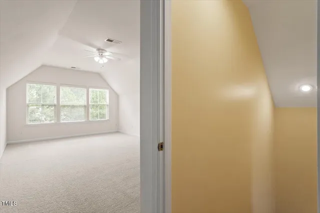 an empty room with chandelier fan and closet area