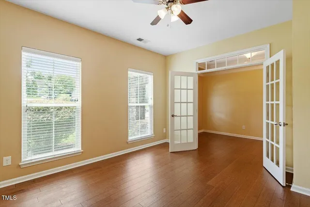 a view of an empty room with a window and wooden floor