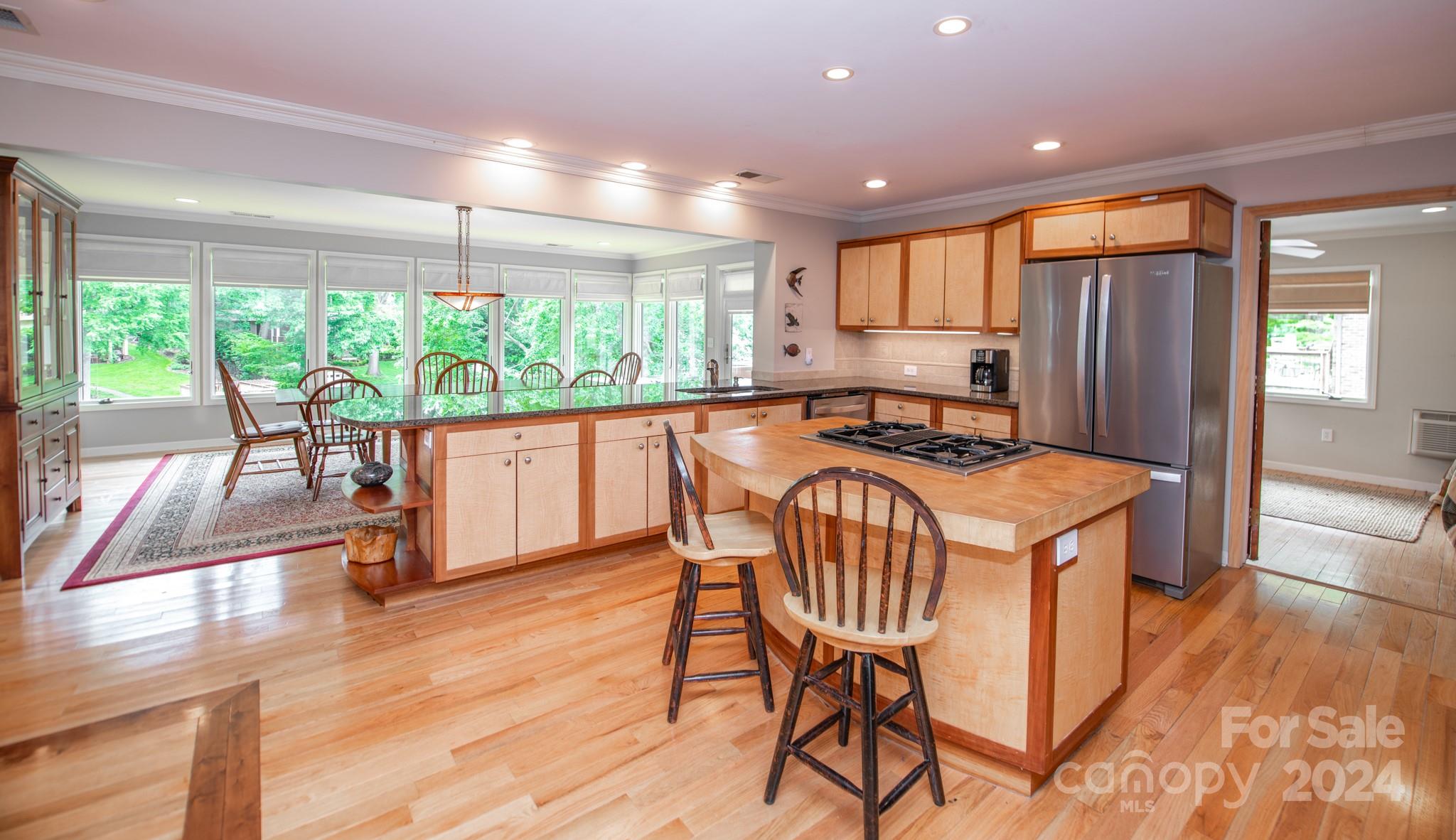 4000 Lake Shore Road South Denver, NC 28037 - Photo 12 of 46 a kitchen with stainless steel appliances granite countertop a stove a refrigerator a microwave oven with a dining table and chairs with wooden floor