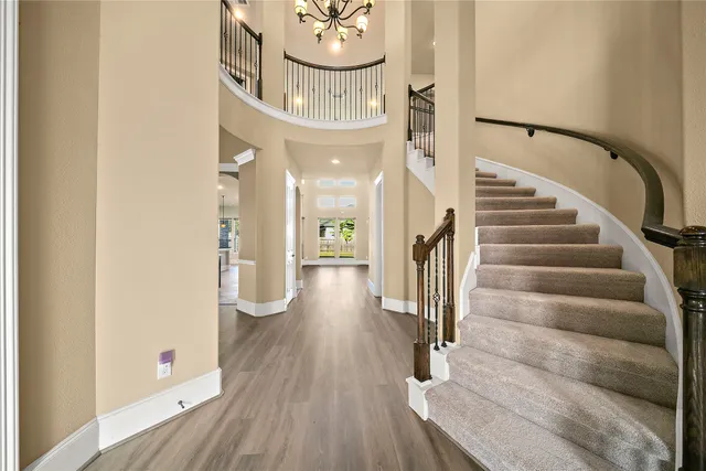 a view of an empty room with wooden floor fireplace and a window