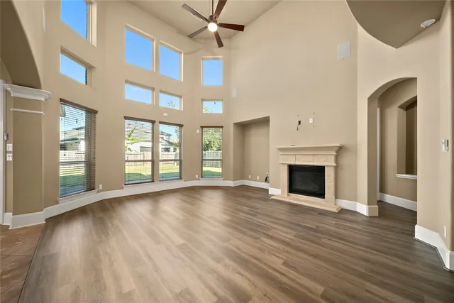a view of an empty room with window and wooden floor