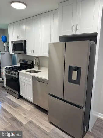 a kitchen with a refrigerator sink and cabinets