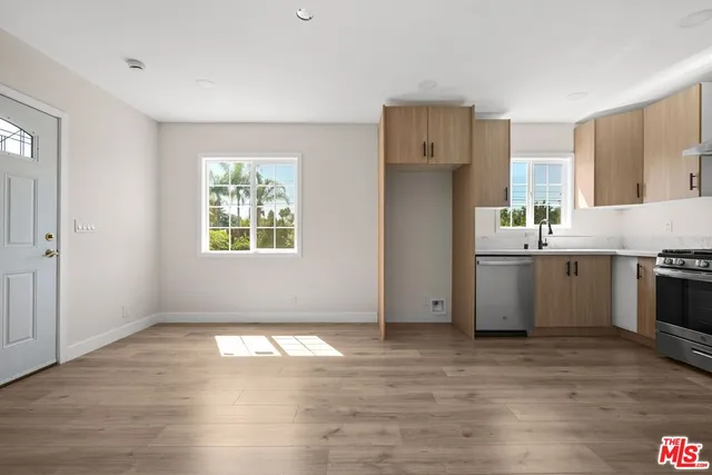 a kitchen with stainless steel appliances a stove a refrigerator and a sink